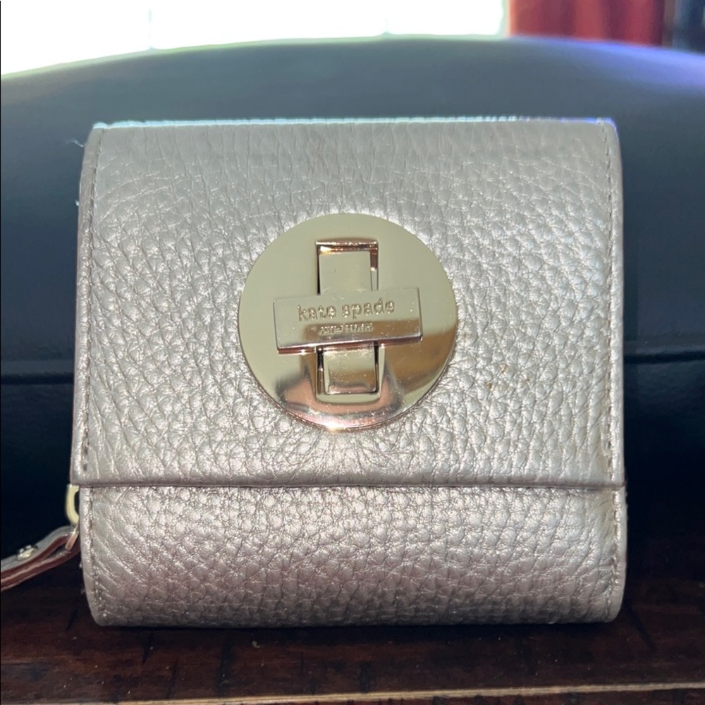 Kate Spade Metallic Silver Trifold Wallet featuring a  pyramid turn-lock closure